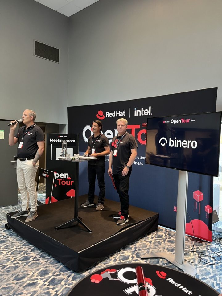Talking about Red Hat open source on a stage. Pratar om Red Hat open source på en scen.