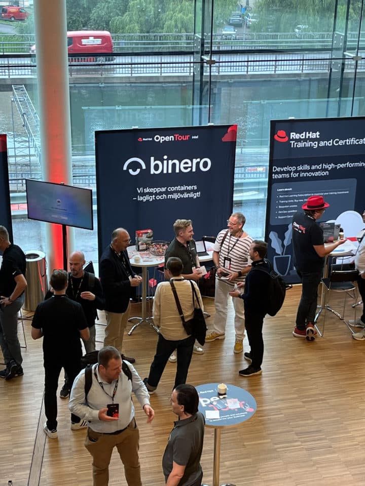 Binero booth at a trade fair by a window. Some visitors. Binero-monter vid ett fönster på en mässa. Några besökare.