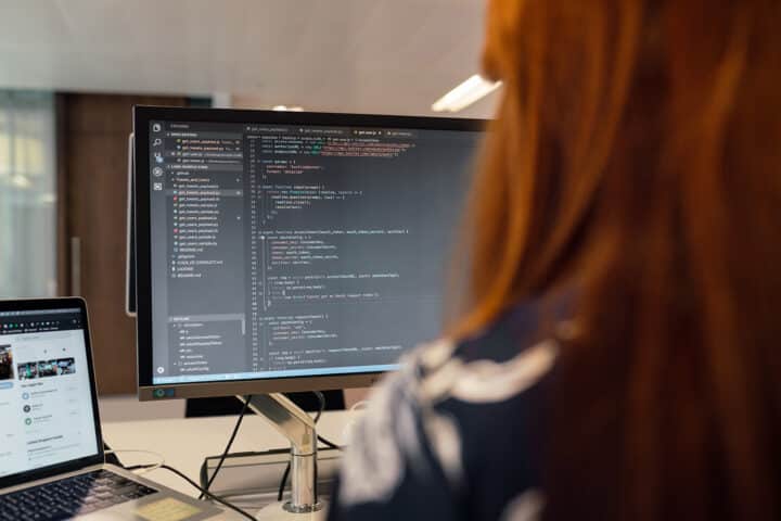 Woman and computer screen with code. Kvinna och datorskärm med kod. servicedesk